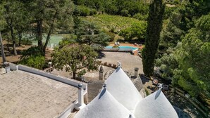 Une vue d’une villa avec piscine, entourée d’une végétation luxuriante et d’arbres.
