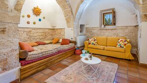 Un salon confortable avec un canapé, un divan jaune et une table basse.