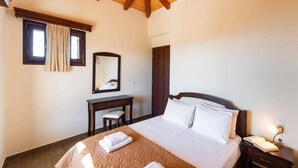 A bedroom with a bed, a desk, a chair, a mirror, and a nightstand. - Villa Drimonas Erato by Villa Plus (Lefkada)