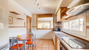 A compact kitchen with a dining area, a window providing natural light, and a built-in stove.