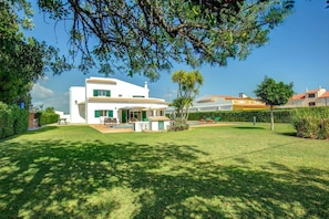 Una casa blanca de dos pisos con un patio y una piscina.