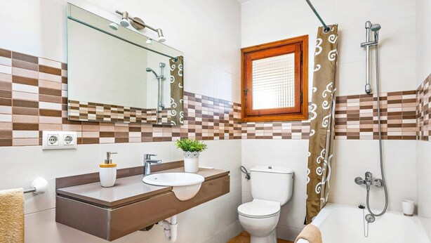 A bathroom with a sink, toilet, and bathtub. - Villa Caterina by Villa Plus (Alayor)