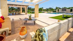 An outdoor patio area with a pool, seating, and a pergola. - Villa Flavia by Villa Plus (San Vito dei Normanni)
