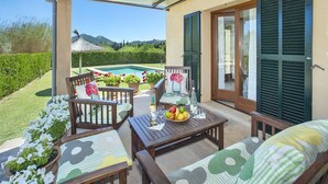 A patio with wooden furniture, a pool, and a view of the mountains. - Villa Figueral by Villa Plus (Mallorca)