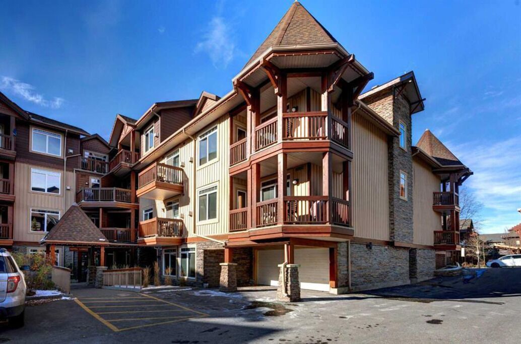 A multi-story hotel with balconies, a ski lodge, and a parking area.