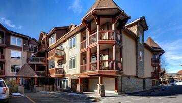 A multi-story hotel with balconies, a ski lodge, and a parking area.
