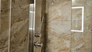 Un receveur de douche moderne doté d’un pommeau de douche incurvé et de boutons de commande.