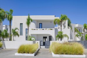 A modern two-story building with a flat roof, white exterior walls, and a central entrance.