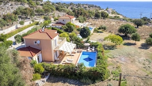 Villa Zeus Skala, eine Villa im mediterranen Stil mit Terrakottadächern, einem Swimmingpool und Meerblick.