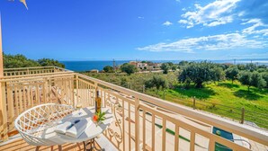 Ein Balkon mit Blick auf das Meer und ein Dorf.