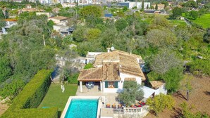 An aerial view of a house with a swimming pool, surrounded by greenery and a hilly landscape. - Villa Rabasso by Villa Plus (Pollença)