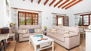 A spacious living room with two sofas, a coffee table, and a dining area with a table and chairs.
