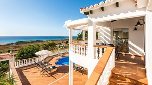 A white building with a pool and a view of the sea. - Villa Casa Bonita by Villa Plus (Alayor)