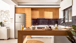 Una cucina moderna con mobili in legno, un frigorifero in acciaio inossidabile e un angolo colazione sul bancone.