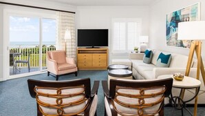 A hotel room with a balcony, a sofa, a television, and a dining area with chairs. - Marriott's SurfWatch (Hilton Head Island)