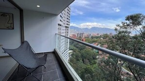 Een balkon met uitzicht op een stadslandschap en bergen.