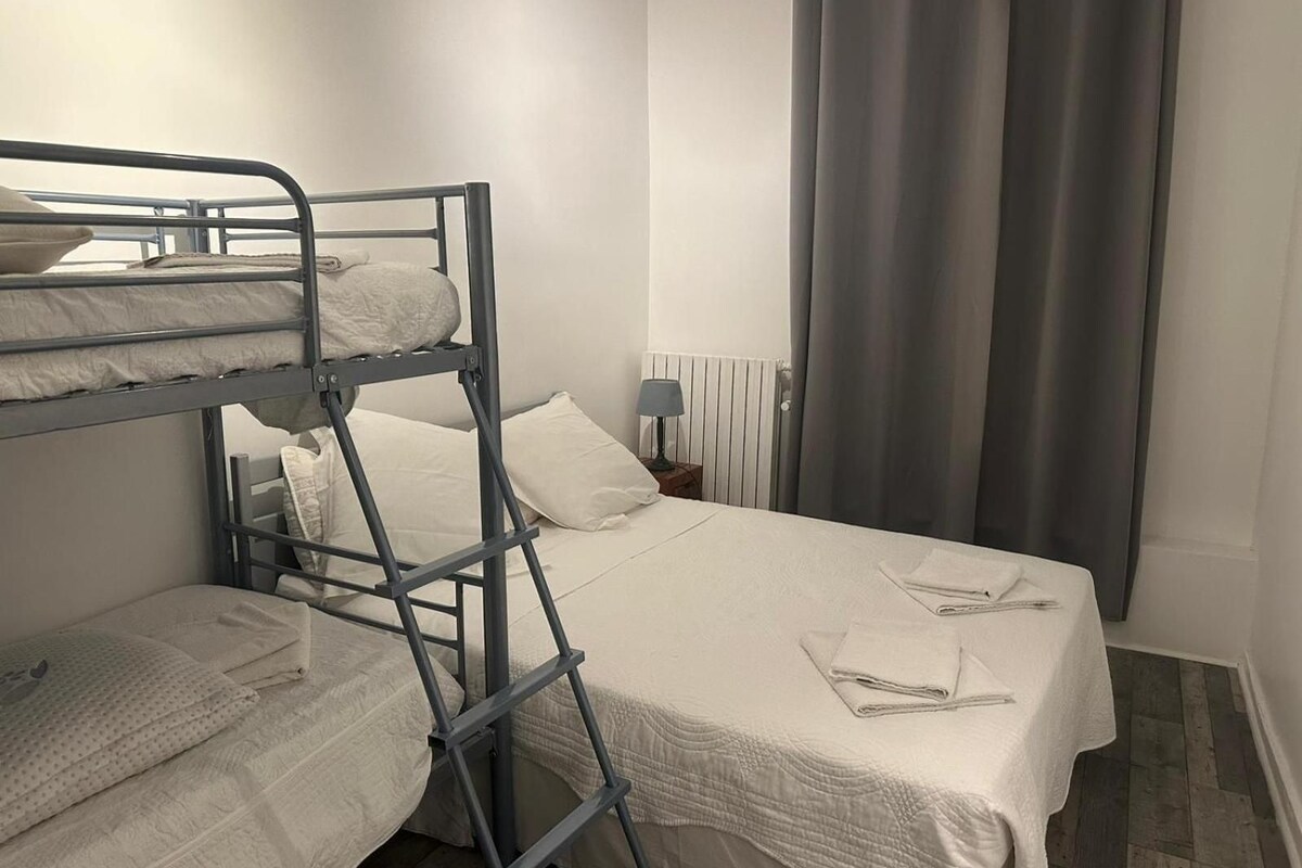 A bunk bed room with a bedside table and a lamp.