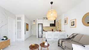 A modern living room with a sofa, coffee table, and dining area. - Casa Ana (Costa Adeje)