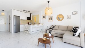 A modern living room with a sofa, coffee table, and dining area. - Casa Ana (Costa Adeje)