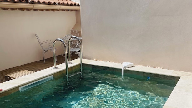 A clear swimming pool with a tiled edge, a metal ladder, and a small white object on the edge. - L'écurie - New house for 5 people, swimming pool (Portiragnes)