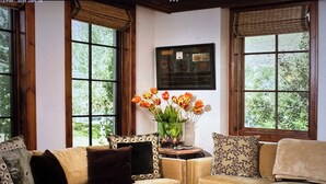 A cozy living room with a beige sofa, a wooden coffee table, and a vase of flowers. - Ritz-Carlton Club, Vail, Two Bedroom Residence (Vail)
