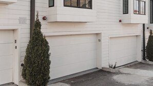 Un bâtiment blanc doté de nombreuses fenêtres et de portes de garage, dont une porte de garage portant le numéro « 10 ».