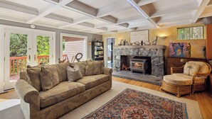 Una sala de estar acogedora con chimenea, un sofá y un sillón.