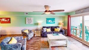A cozy living room with a ceiling fan, two sofas, a coffee table, and a view of the outside. - Summer House West C202 (Gulf Shores)