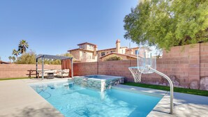 A swimming pool with a hot tub, lounge chairs, and a basketball hoop. - Spacious Las Vegas Home w/ Private Pool + Hot Tub (Las Vegas)
