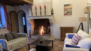 Ein gemütliches Wohnzimmer mit Kamin, einer Couch, einem Couchtisch und einer Lampe.