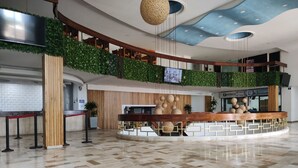 A modern lobby with a reception desk, a staircase, and a ceiling with a unique design. - Apartamento con vista al mar Cartagena (Cartagena)