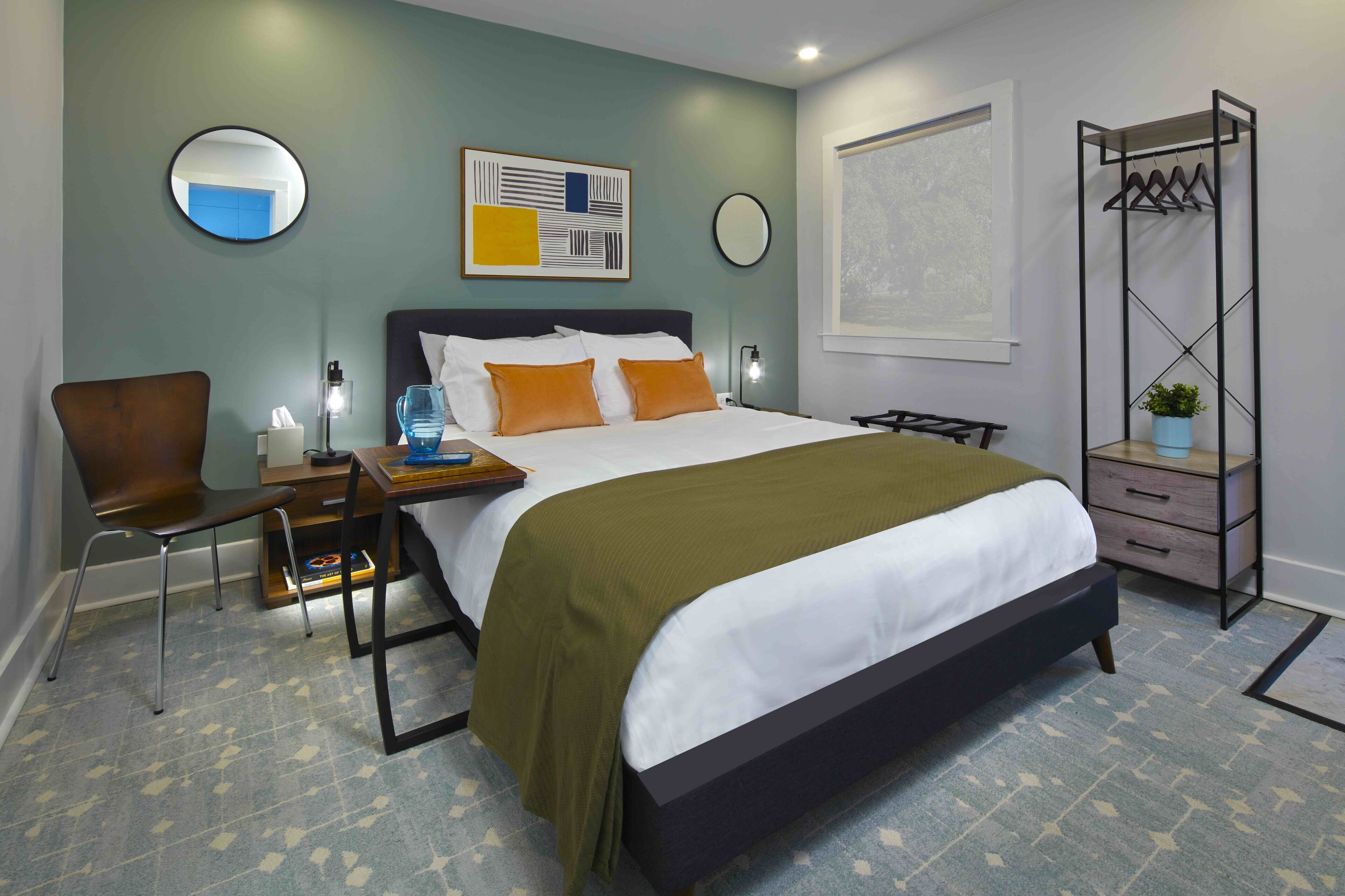 Een moderne slaapkamer met een groot bed, een stoel, nachtkastjes en een wandplankje met een plant.