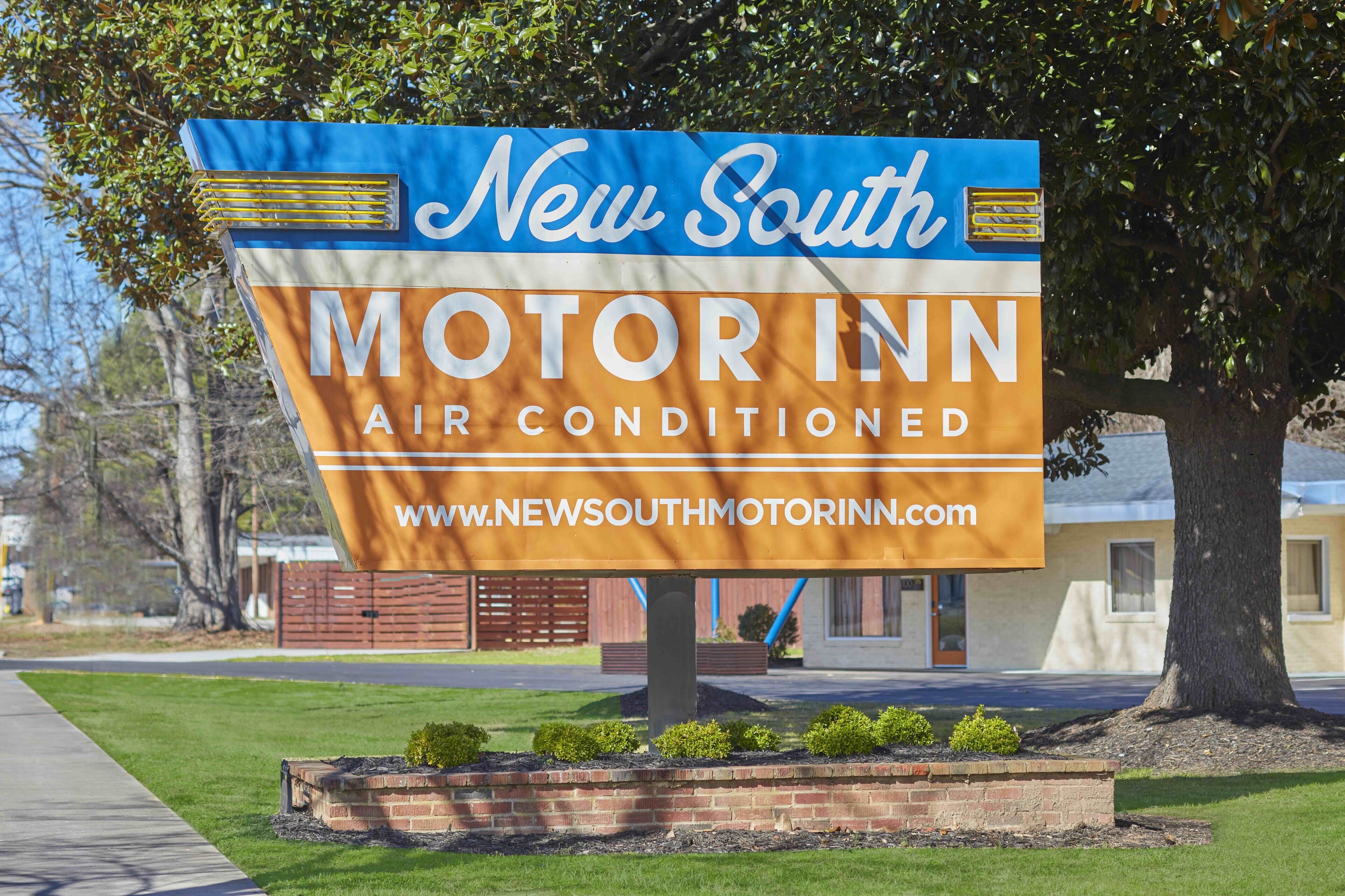 Letrero del New South Motor Inn anunciando aire acondicionado y una dirección web.