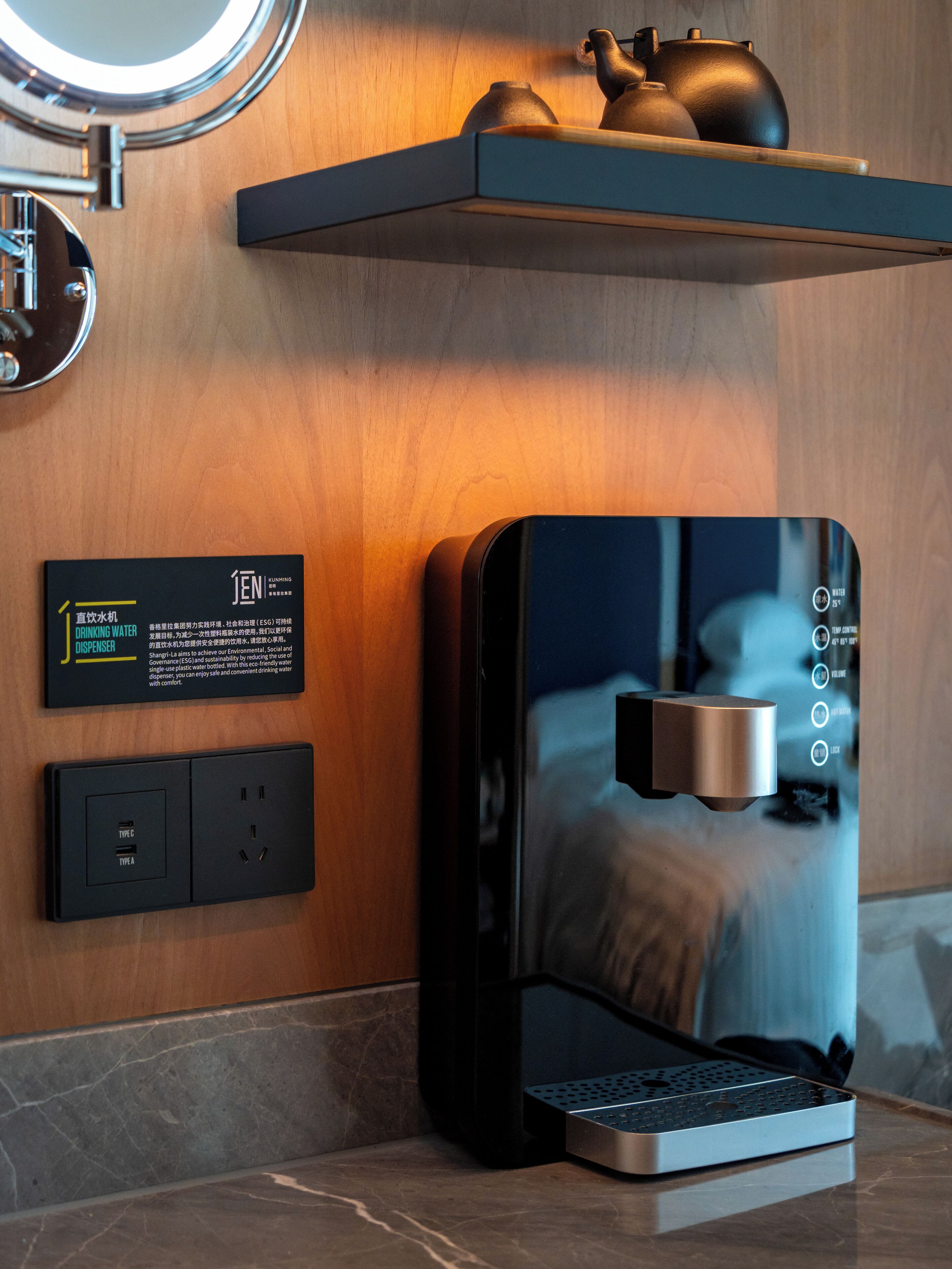 Eine moderne Küche mit integrierter Kaffeemaschine, einem Wasserkocher und einem Teekessel auf einem Holzregal.