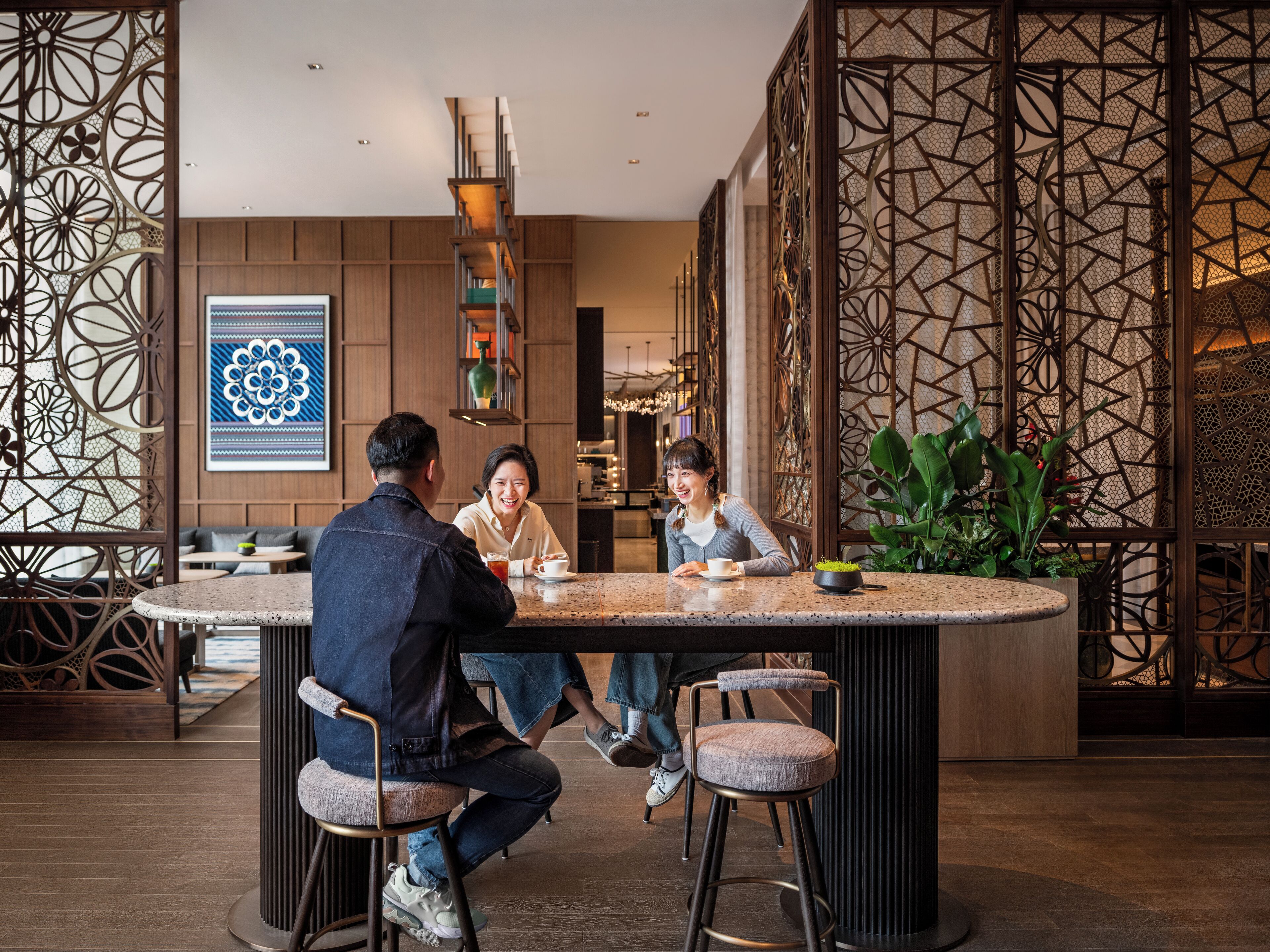 A modern interior with a round bar area, wooden paneling, and a decorative screen.