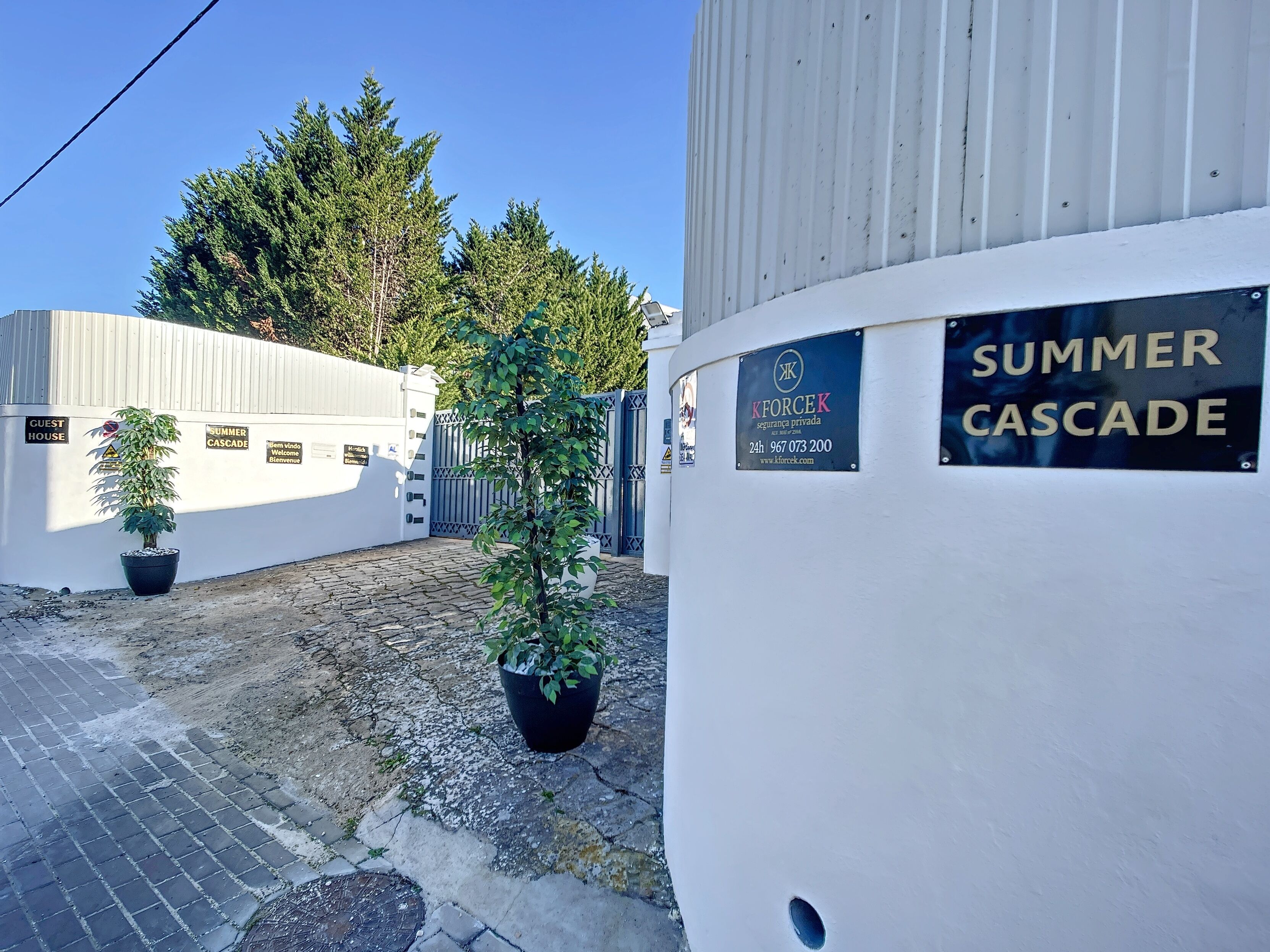 A gated area with a sign for 'SUMMER CASCADE' and a 'KFORCEK' security sign.