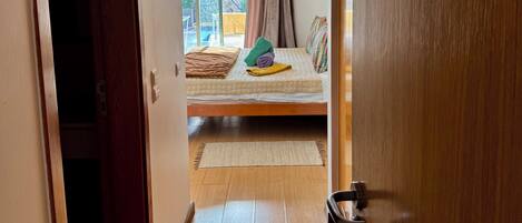 Une chambre d’hôtel avec un lit, une fenêtre avec des rideaux, une enseigne indiquant « SUITE CORAL » et un plancher en bois.