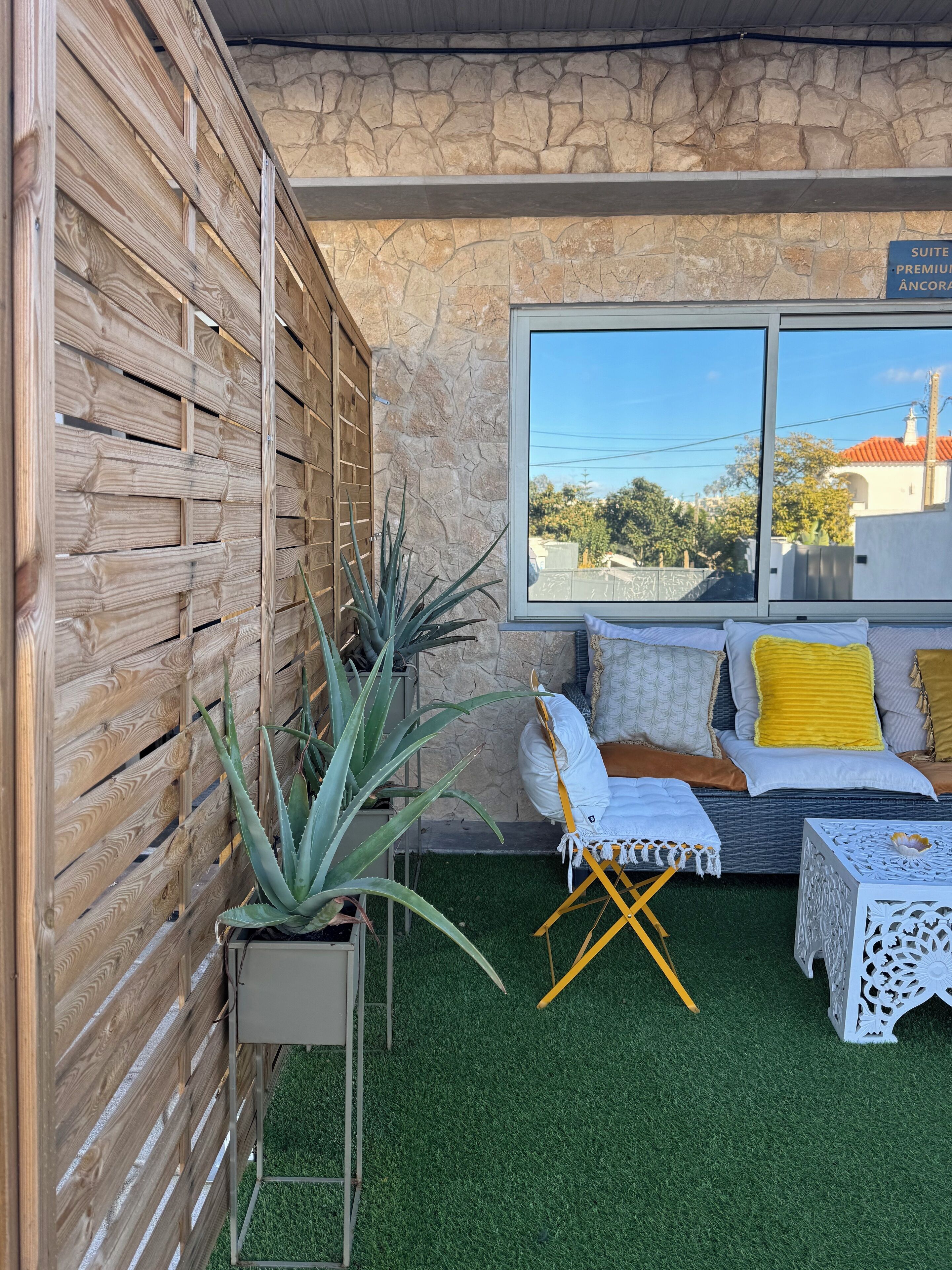 A suite with a stone wall, wooden slats, and a view of the city.
