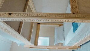 Een kamer met een houten bed, een raam en een deur.