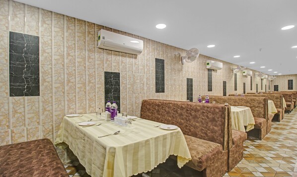 A restaurant with booths and tables, air conditioning units, and tiled walls.