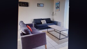 A living room with a sofa, a coffee table, and a rug.