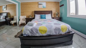 Ein Schlafzimmer mit Bett, Deckenventilator, Holz-Kopfstütze, Nachttisch, Stuhl, Spiegel und Fenster.