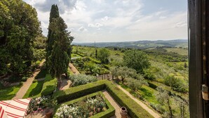 A garden with neatly trimmed hedges, a tall cypress tree, and a view of rolling hills in the distance. - Villa in La Presura with 8 bedrooms sleeps 16 (La Presura)
