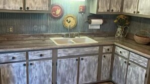 A kitchen with wooden cabinets, a sink, and a backsplash.