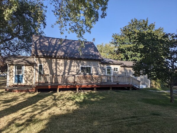 A two-story house with a front porch, a small attached garage, and a grassy yard.