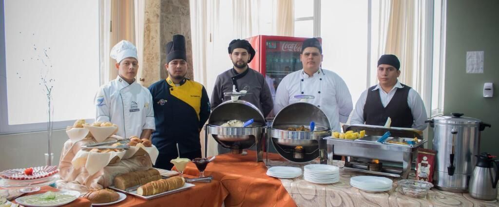 Montaje de bufé con diversos alimentos y utensilios de cocina.