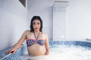 A person in a colorful bikini in a hot tub with blue mosaic tiles. - HOTEL GOLDEN VISTA (Santo Domingo de los Colorados)