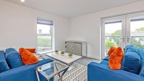 A modern living room with a sofa set, a coffee table, and a small cabinet. - Gospel Heights by Guestz (Heswall)