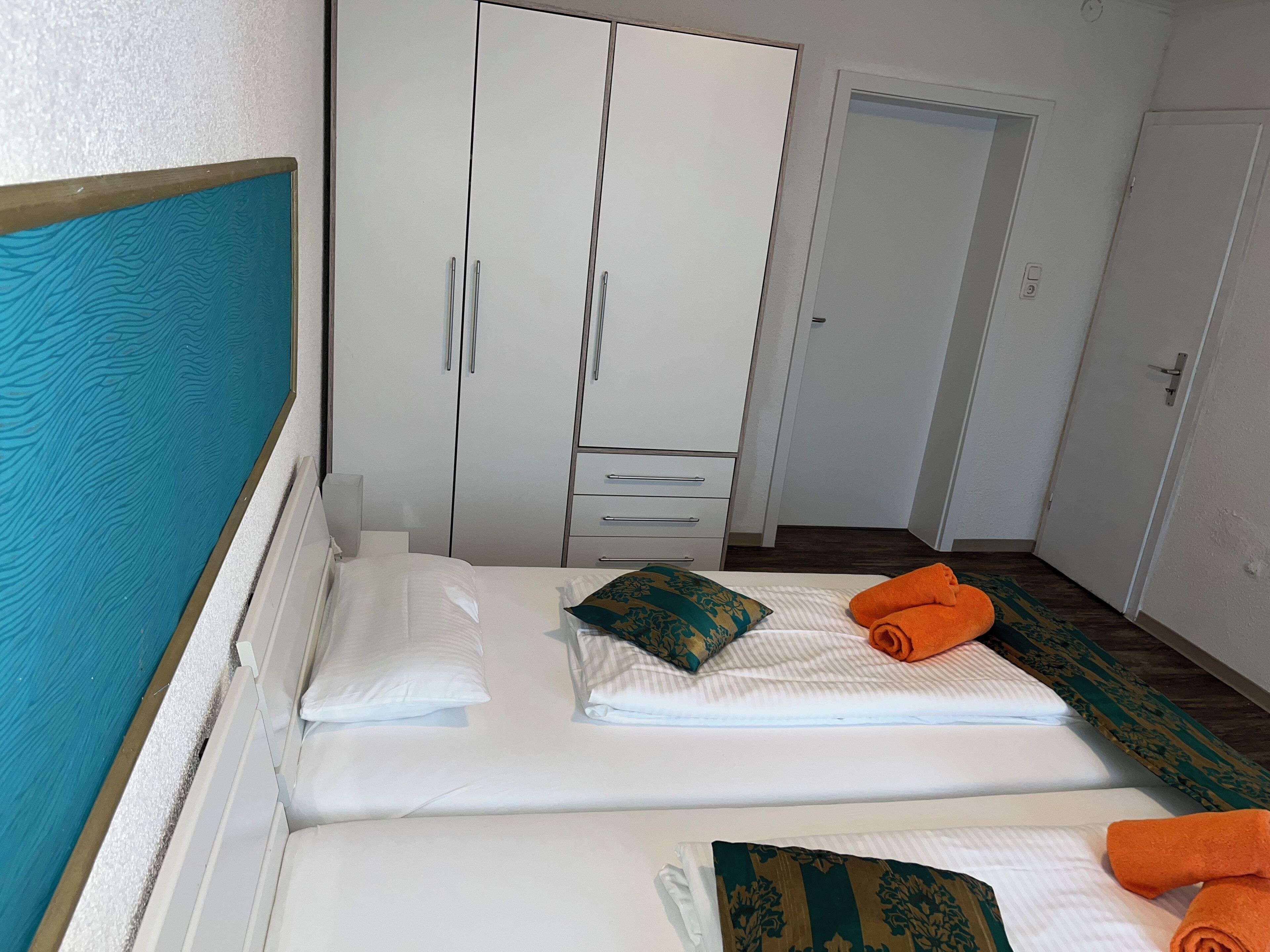 Una habitación de hotel con una cama, un armario y una puerta.