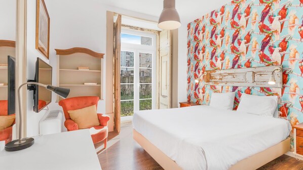 Relax in a stylish room with a large bed, desk, and TV, offering a view of the outside.